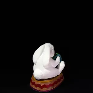 Rear view detail of a white resin Easter bunny sitting on a patterned decorative base