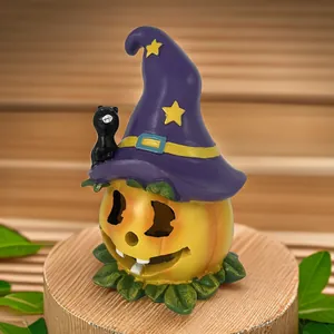 Figurine citrouille d'Halloween avec chapeau de sorcier violet et chat noir sur bois