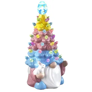 Detail of lit Easter gnome ornament with colorful LED tree hat and small white bunny