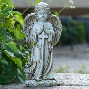 Close-up of resin angel statue with white cross and fine wing textures for garden decor