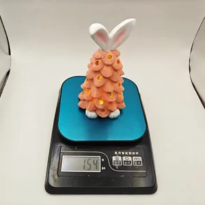 Detailed view of glowing gnome ornament with rabbit ears on a digital scale weighing 154g