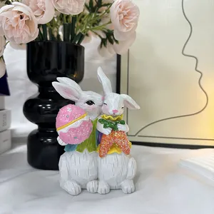 Detailansicht von Osterhasen-Figuren aus Harz mit glitzerndem Ei und Karotte