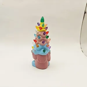 Close-up of resin gnome figurine holding a colorful tiered Christmas tree with LED lights