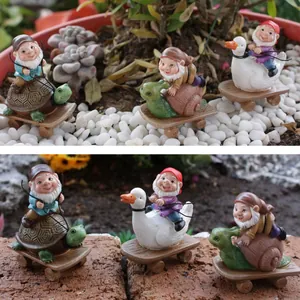 Detailansicht von drei Gartenfiguren auf Tierrollern inmitten von Sukkulenten