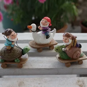Detailansicht von drei Gartenfiguren auf Schildkröte, Gans und Schnecke aus Kunstharz