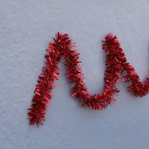 Gros plan sur une guirlande de Noël rouge ondulée avec finition métallique brillante