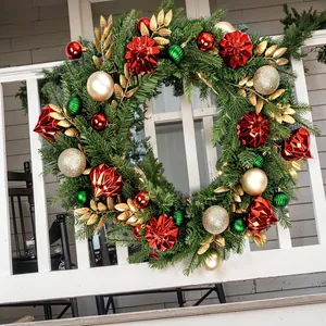 Classic Christmas wreath with red and gold ornaments on a white fence for festive decor