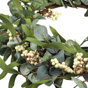 Green eucalyptus wreath with white berries and natural rattan base for wedding decor