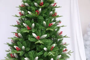 Close-up of artificial Christmas tree with red berries, pine cones and white flocking detail
