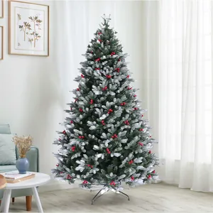 Dettaglio di un albero di Natale innevato con bacche rosse e aghi in PVC resistente