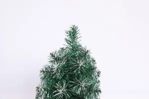 Detailed macro view of green PVC Christmas tree needles with realistic white snow flocking