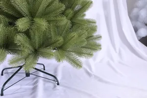 Détail du sapin de Noël artificiel vert montrant le support de base en métal à quatre pieds