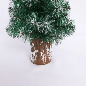 Miniature green Christmas tree with snowy tips and rustic wood base for table decor