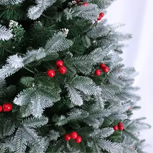 Dettaglio di un albero di Natale innevato con aghi verdi e bacche rosse vivaci