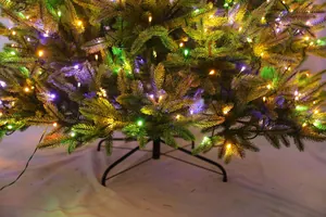 Dettaglio di luci LED colorate su albero di Natale artificiale con supporto in metallo