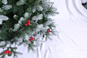 Dettaglio rami di albero di Natale con bacche rosse e aghi di pino con effetto neve
