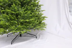 Detail of green PE Christmas tree with realistic needles and sturdy black metal base stand