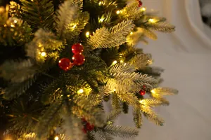 Dettaglio di rami di albero di Natale innevati con bacche rosse e luci LED calde