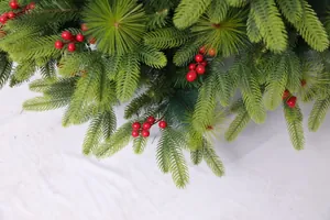 Close-up of artificial pine needles with red berries for Christmas home decoration