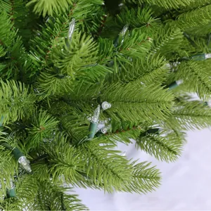 Detailansicht eines dichten PE-Weihnachtsbaums mit integrierten warmweißen LED-Lichtern