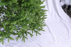 Close-up of green PE artificial Christmas tree needles with integrated LED string lights