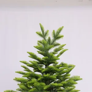 Realistic artificial PE Christmas tree with lush green needle branches in a tower shape