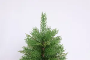 Close-up of realistic green PE needle branches and brown trunk on a small Christmas tree