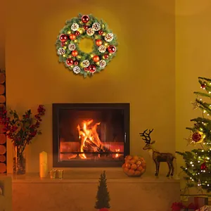 Close-up of a Christmas wreath with pine cones and LED lights above a fireplace