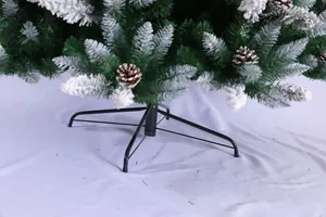 Detail of Christmas tree metal base with snowy pine needles and natural pine cones