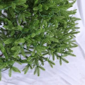 Close-up of realistic green PE Christmas tree needles with integrated LED fairy lights