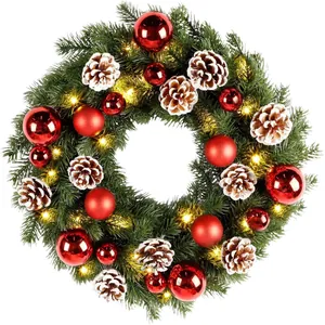 Christmas wreath with red baubles, snow-tipped pine cones and warm white LED lights