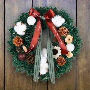 Couronne de Noël avec pommes de pin coton et ruban Merry Christmas sur fond bois