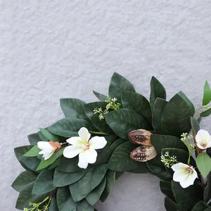 Detalle de hojas de magnolia realistas y flores blancas en una guirnalda de Navidad