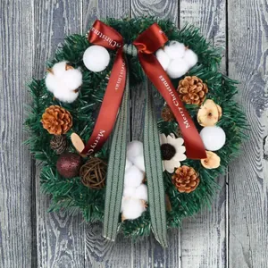 Couronne de Noël avec pommes de pin, coton et nœud rouge Merry Christmas sur bois bleu
