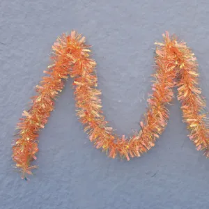 Close-up of fluffy orange iridescent tinsel garland with a reflective metallic finish