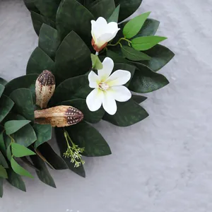 Guirnalda de Navidad artificial con hojas de magnolia y flores sobre fondo de piedra