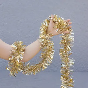 Golden Christmas tinsel garland for wedding and festive party decoration held by a model