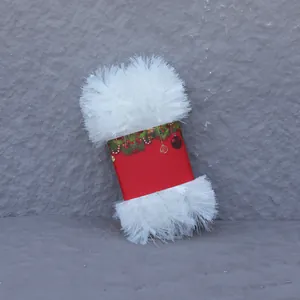 Detail of white fluffy Christmas tinsel garland with festive red packaging card decor