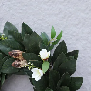 Detalle de la guirnalda de hojas de magnolia con flores blancas y vainas de semillas