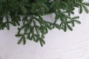 Close-up of green PVC faux pine branches with dense needles for Christmas tree decor