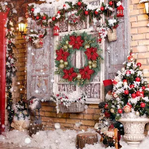 Ghirlanda natalizia con stelle di Natale rosse e palline d'oro su finestra innevata