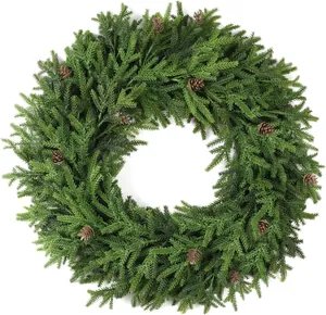 Close-up of artificial pine wreath with realistic needles and natural pine cones