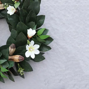 Guirnalda de Navidad artificial con hojas de magnolia y flores blancas sobre piedra