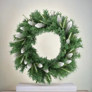 Artificial Christmas wreath with snowy pine cones and green needles for festive home decor