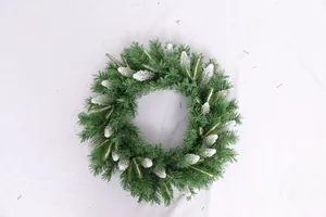 Close-up of artificial green Christmas wreath with snowy pine cones on white background