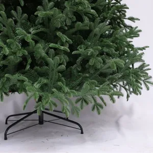 Artificial green PVC Christmas tree with sturdy black folding metal stand on white background