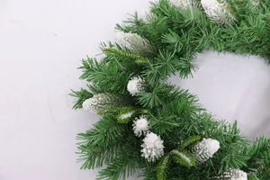 Close-up of green PE and PVC Christmas wreath with realistic white snow flocking detail