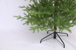 Detalle de ramas de árbol de Navidad de PE verde con soporte estable de metal negro
