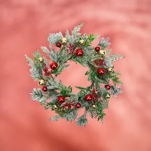 Détail d'aiguilles de pin givrées avec baies rouges et boules de Noël dorées et rouges
