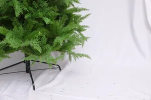 Detail of green artificial Christmas tree needles with a sturdy black metal stand